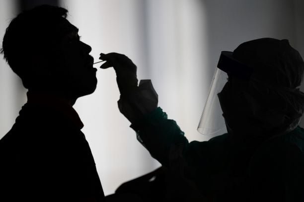 A-health-worker-uses-a-swab-to-collect-a-sample-for-COVID-19-coronavirus-testing-from-a-man.-AFP-photo.jpg