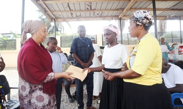 PWDs-Hajia-Adam-Kuta-left-presenting-a-cash-donation-to-one-of-the-beneficiaries.jpg