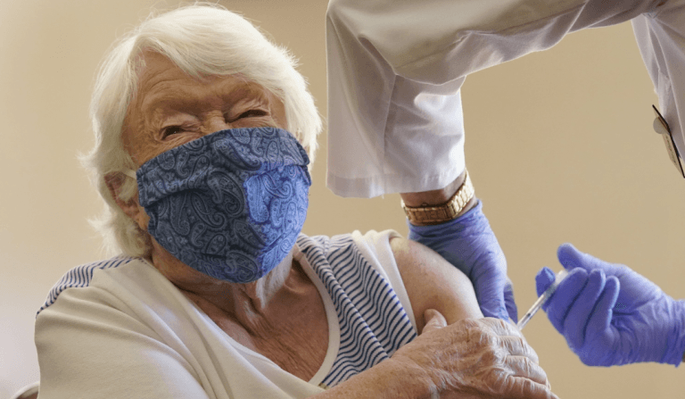 An-elderly-woman-taking-Covid19-jab.png